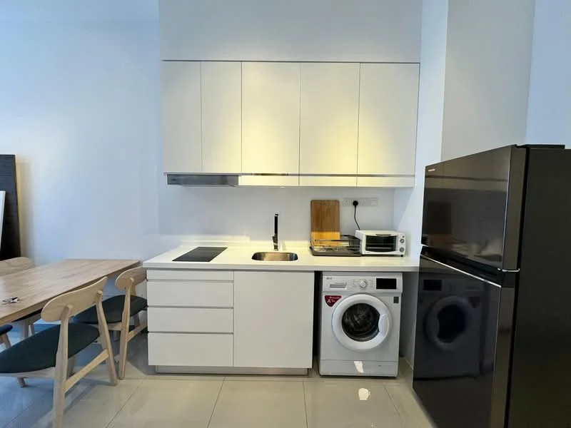 Kitchen features: white cabinetry, stainless-steel sink, chrome pull-down faucet, built-in induction hob, microwave, front-load washing machine, black refrigerator, grey tile flooring, under-cabinet lighting, wood dining table, 4 wooden chairs with upholstered seats; style: modern.