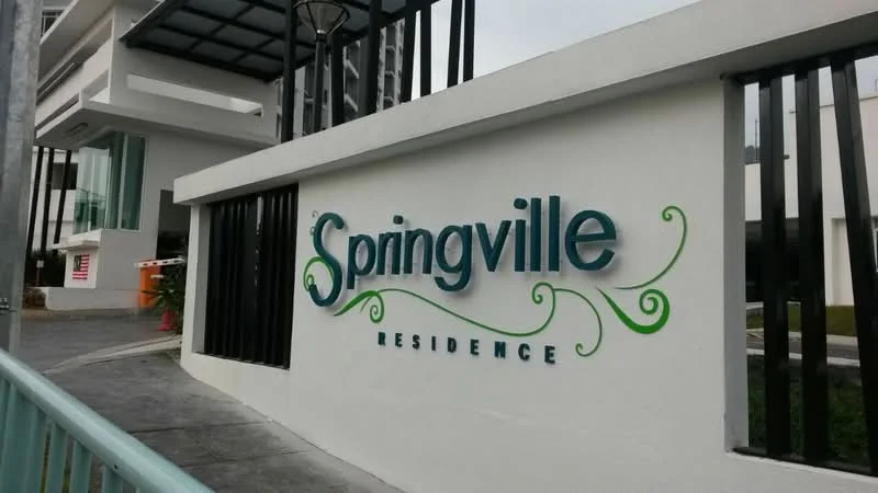 Exterior features: signage with the name 'Springville Residence', white painted facade, decorative green elements on signage, concrete pathway, landscaped area with plants, modern architectural design, fencing with vertical bars, lighting fixture on the wall; style: modern.