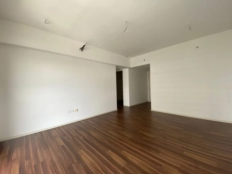 Room features: wooden flooring, white painted walls, recessed ceiling lights, open layout, large unobstructed space, no visible furniture, neutral color scheme, smooth ceiling; style: modern.
