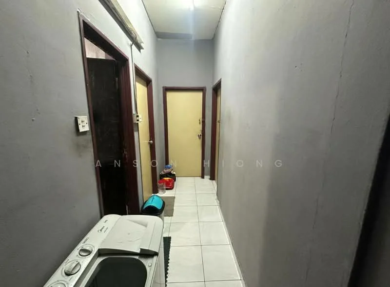 Hallway features: grey painted walls, white tiled flooring, two wooden doors, one beige door, light fixture on ceiling, washing machine, door mat, small storage container.