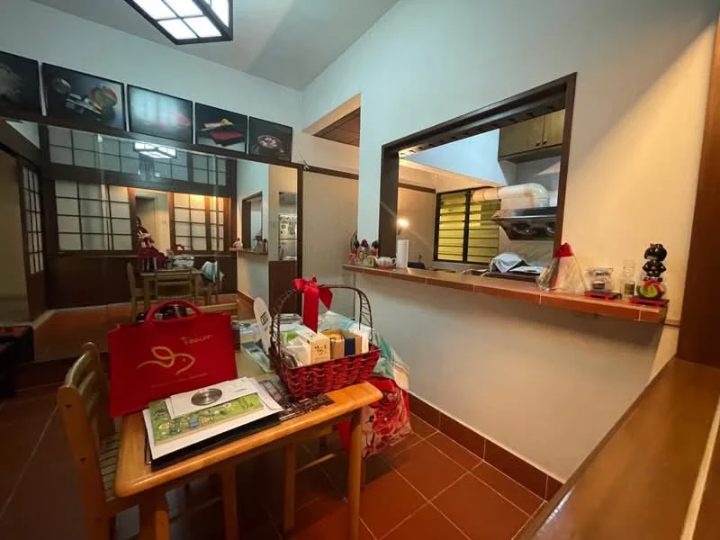 Dining features: wooden dining table, 4 wooden chairs, red decorative items, framed artwork on walls, tile flooring, open kitchen view, countertop with storage, decorative basket, various items on table; style: traditional; view: kitchen. Room features: white painted walls, wooden paneling, sliding door, light fixture.