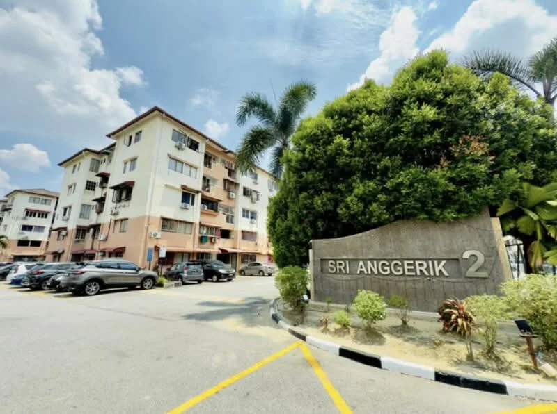 Exterior type: low-rise apartment block; features: cream painted facade, 3-storey low-rise, landscaped garden with palm trees, manicured shrubs, parking lot with multiple vehicles, signage with building name, surrounded by greenery, clear blue sky; style: modern.