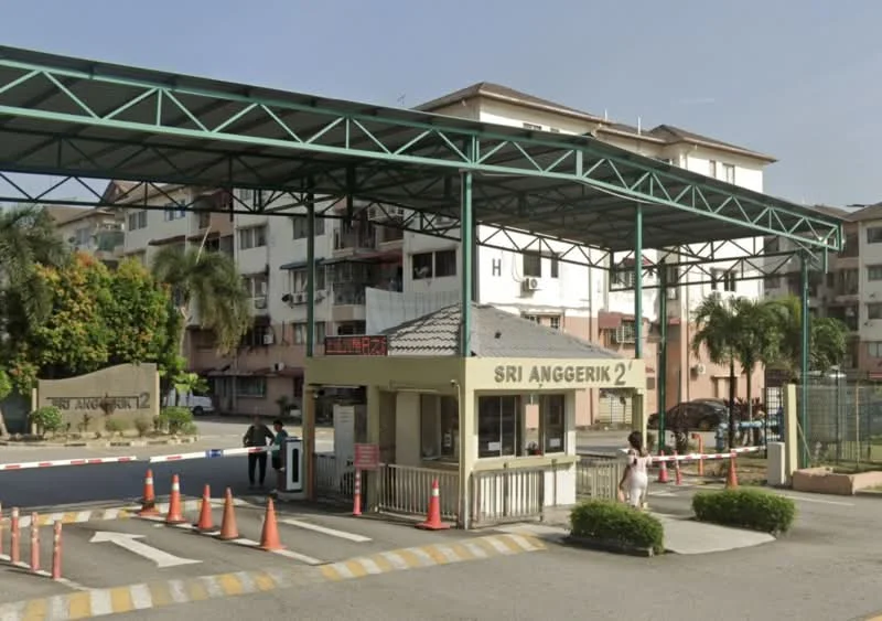 Exterior type: low-rise apartment block; features: guard house at entrance, gated entry, paved driveway, landscaped greenery, signage with 'SRI ANGERIK 2', traffic cones, covered entrance, surrounding residential buildings; style: modern.