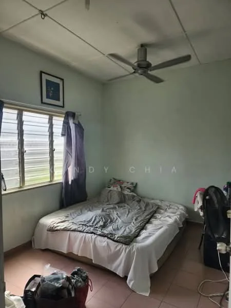 Bedroom features: queen-size bed with white bedding, light green painted walls, ceiling fan, window with sheer curtains, tile flooring in light color, framed artwork on wall, nightstand with items, cluttered corner with bags.