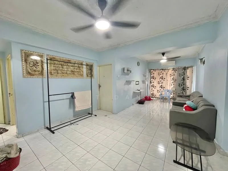 Living features: white painted walls, tiled flooring, 5-blade ceiling fan with light, wall-mounted air conditioning unit, sofa in grey, decorative wall art, curtains with floral pattern, clothes rack, small dining table, red decorative cushions.
