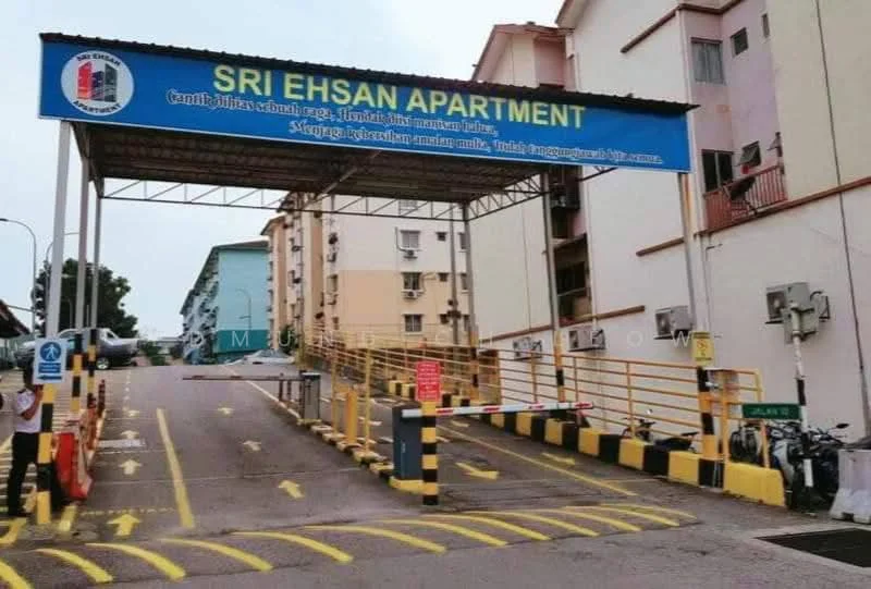 Exterior type: low-rise apartment block; features: entrance gate with signage, covered driveway, marked parking spaces, yellow and black striped barriers, surrounding residential buildings, bicycle parking area; style: modern.
