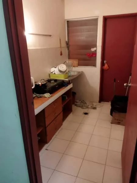Kitchen features: white tiled walls, white tiled flooring, wooden cabinetry, countertop, sink, stove, window with blinds, red door, open shelving, dish rack, cleaning supplies, floor space, wall-mounted hooks.
