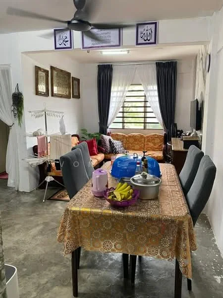 Dining features: dining table with patterned tablecloth, 6 dining chairs, decorative fruit bowl with bananas, ceiling fan, concrete flooring, wall-mounted TV, sofa with patterned upholstery, curtains, wall art with Arabic calligraphy, clothes drying rack; style: modern.