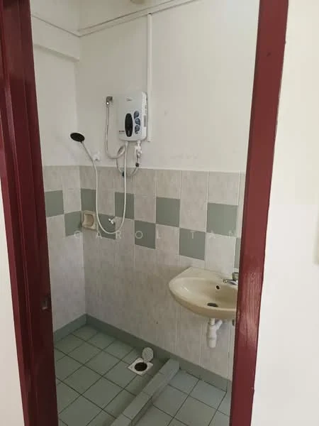 Bathroom features: shower with handheld showerhead, wall-mounted water heater, sink with faucet, toilet, grey and white tiled walls, green accent tiles, ceramic tile flooring, drain in floor.