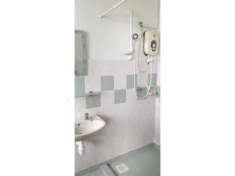 Bathroom features: white ceramic sink, chrome basin mixer faucet, shower with handheld showerhead, wall-mounted water heater, light green and white tiled walls, light green tiled flooring, mirror above sink, shower curtain rod, drain on floor.