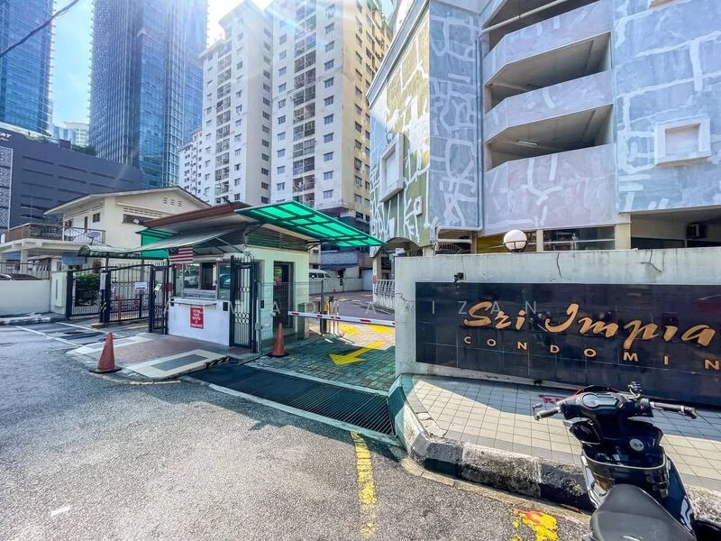 Exterior type: high-rise condominium; features: guard house at entrance, gated entry, security booth, paved driveway, signage with 'Sri Jumira Condominium', surrounded by high-rise buildings, clear sky, parking area, traffic cones, intercom panel; style: modern.