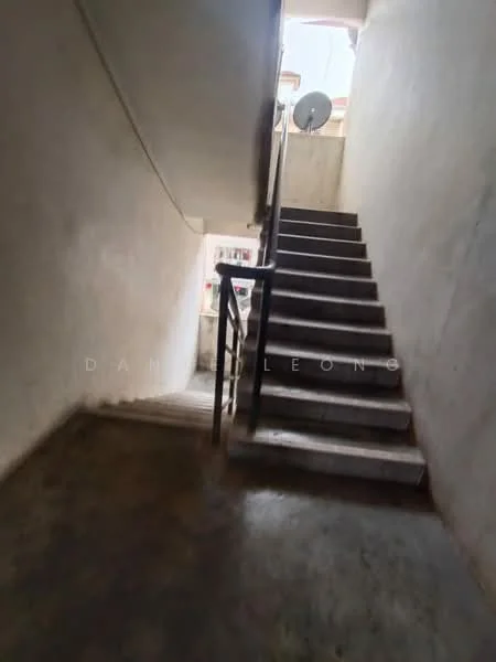 Room features: concrete flooring, plain white walls, staircase with metal railing, natural light from upper level, exposed ceiling, wall-mounted satellite dish; style: minimalist.