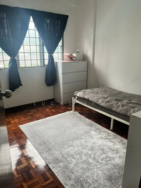 Bedroom features: single bed, grey bedding, wooden flooring, white walls, black curtains, window with grid design, white dresser, area rug with geometric pattern.