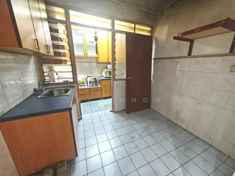 Kitchen features: single-bowl stainless-steel sink, chrome faucet, wood cabinetry in brown, black countertop, white tiled walls, grey tiled flooring, built-in shelves, window with natural light, door leading to another area.