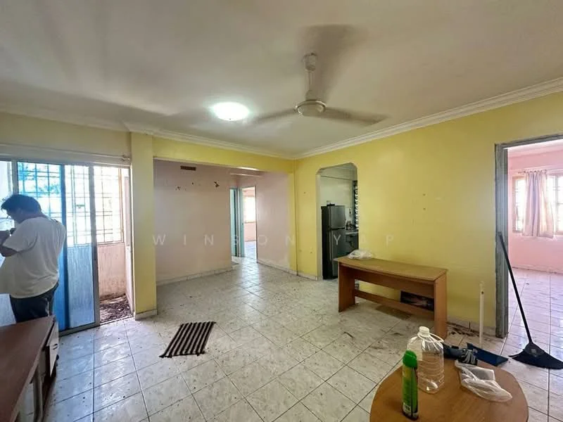 Living features: white painted walls, cream tiled flooring, ceiling fan, large window with sheer curtains, dining table, open layout to adjacent room, wall-mounted light fixture, doorway leading to other rooms. Room features: white painted walls, cream tiled flooring, doorway leading to balcony, kitchen area visible in background.