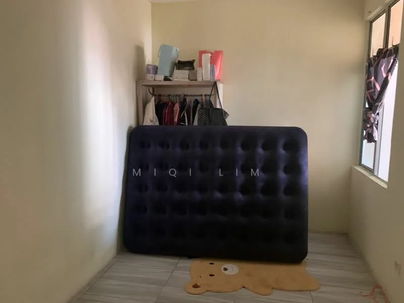 Room features: light yellow painted walls, grey tiled flooring, large inflatable mattress, wooden shelf with clothing, window with sheer curtains, bear-shaped rug.