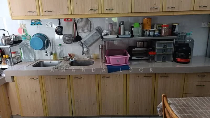 Kitchen features: double-bowl stainless-steel sink, chrome pull-down faucet, laminate countertop, wood cabinetry with yellow finish, microwave, toaster, blender, plastic storage containers, glass water dispenser, kitchen utensils hanging on rack, open shelving, dining table with wooden chairs.