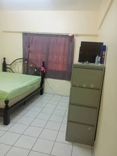 Bedroom features: green bed sheet, black metal bed frame, tile flooring, window with sheer curtains, grey dresser, wall-mounted TV, decorative wall, light yellow painted walls.
