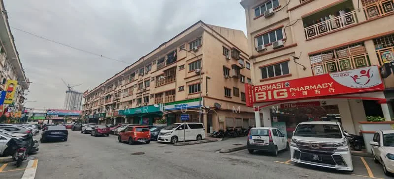 Exterior type: shophouse; features: two-storey shophouse, red signage for pharmacy, various retail shops, parking spaces visible, multiple vehicles parked, balconies on upper floor, street view with overhead cables, urban setting with construction in background; style: traditional.