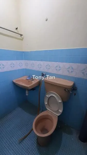 Bathroom features: pink toilet, pink sink, blue tiled walls, white decorative tiles, blue mosaic tile flooring, wall-mounted towel rack, exposed plumbing, single faucet.