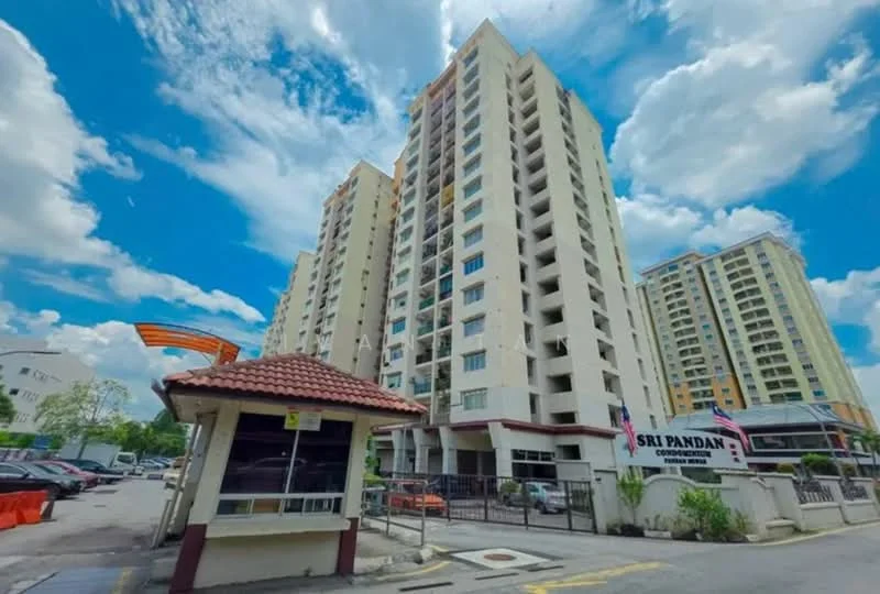 Exterior type: high-rise condominium; features: cream painted facade, glass curtain wall, recessed balconies, approximately 15-storey high-rise, guard house at entrance, gated entry, surrounded by mature greenery, parking lot visible, signage for Sri Pandan condominium; style: modern.