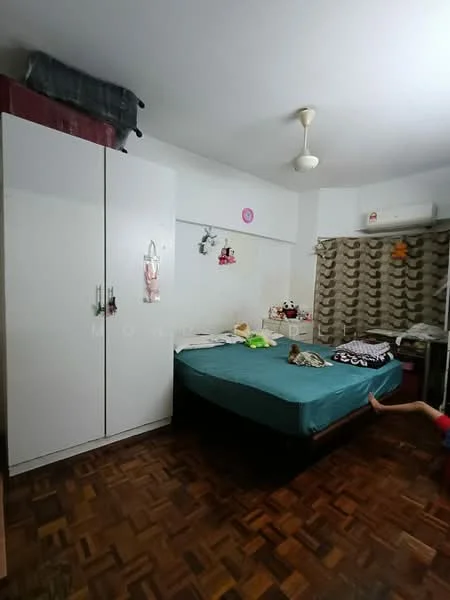 Bedroom features: queen-size bed with teal bedding, white wardrobe with sliding doors, wooden parquet flooring, ceiling fan, wall-mounted air conditioning unit, decorative wall with patterned curtains, shelves with stuffed toys, bedside items on the bed.