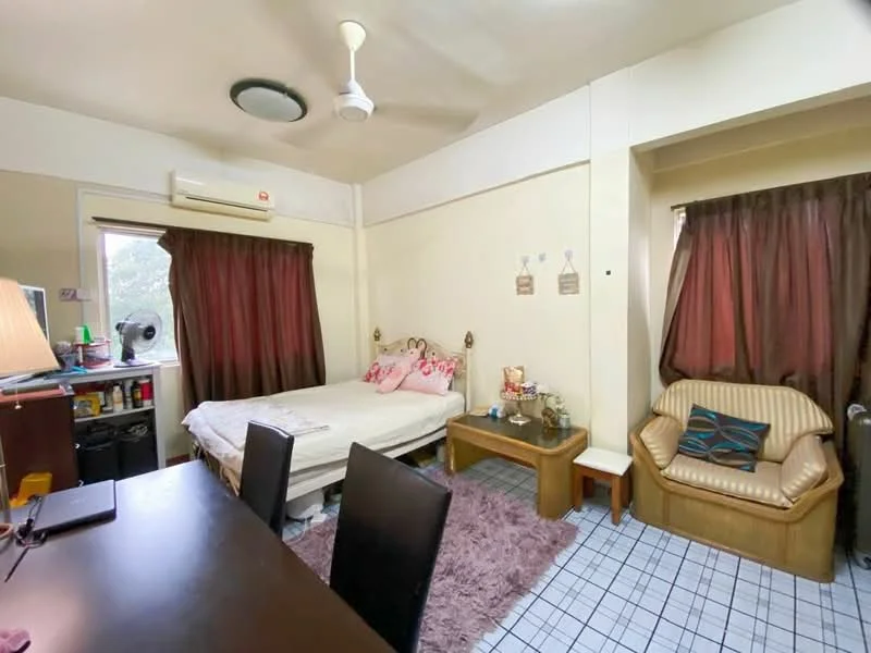 Bedroom features: queen-size bed with floral bedding, wooden bed frame, 2 bedside tables, table lamp, upholstered armchair, wooden coffee table, desk with chair, ceiling fan, wall-mounted air conditioning unit, brown curtains, plaid tile flooring, decorative wall art.