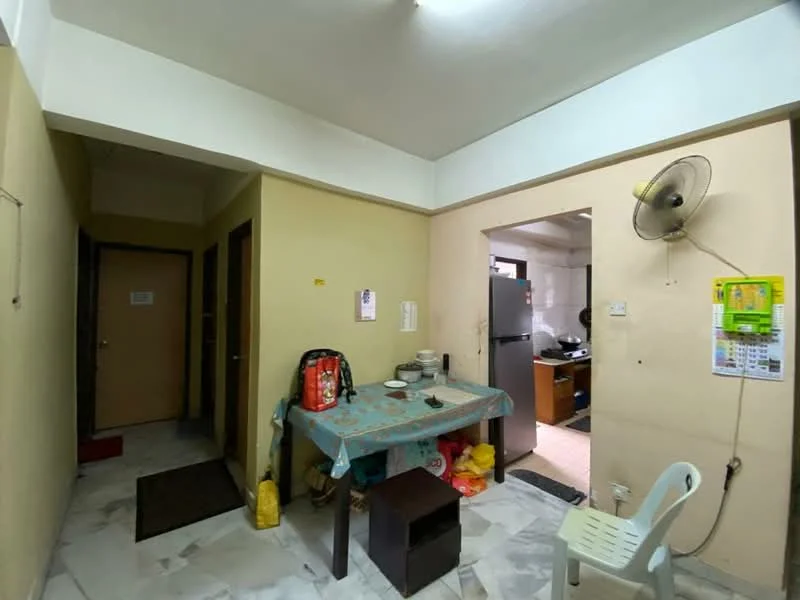 Room features: cream painted walls, marble flooring, table with tablecloth, plastic chair, wall-mounted ceiling fan, doorway to adjacent room, doorway to hallway, refrigerator visible in adjacent room.