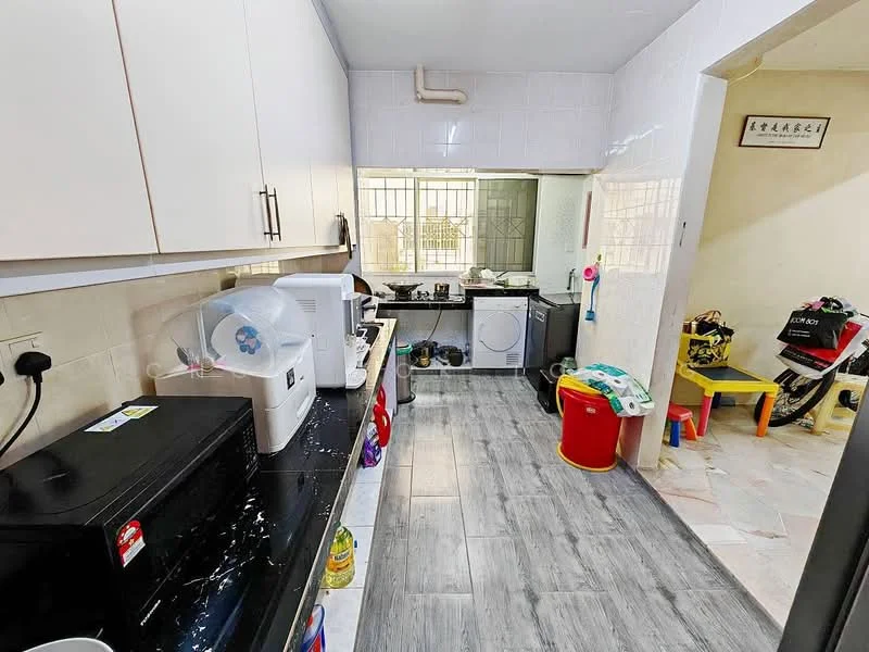 Kitchen features: white cabinets, black countertop, stainless-steel sink, built-in washing machine, microwave, kettle, dishwasher, grey tile flooring, wall-mounted shelves, window with grid pattern, various kitchen utensils, plastic storage containers; style: modern. Room features: tile flooring, yellow plastic bin, colorful storage items, motorbike parked, wall with decorative frame.