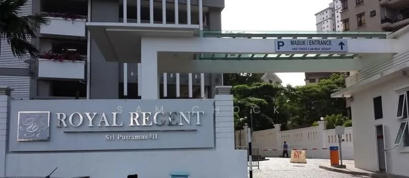 Exterior type: high-rise condominium; features: modern facade, glass curtain wall, signage with 'Royal Regent', entrance gate, paved driveway, surrounded by greenery, parking area, security barrier; style: modern.