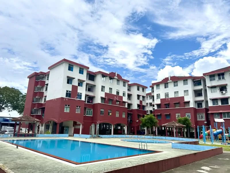 Exterior type: low-rise apartment block; features: red painted facade, flat roof, approximately 4-storey, swimming pool, pool deck with loungers, children's playground, manicured lawn, surrounded by mature greenery; style: modern.