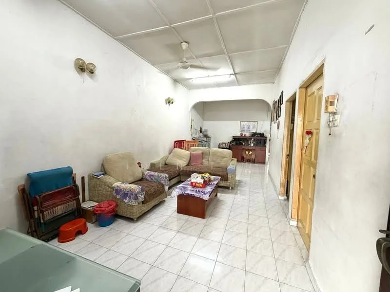 Living features: white painted walls, tile flooring, ceiling fan, 3-seater fabric sofa in beige, 2-seater fabric sofa in beige, coffee table, decorative table with flowers, open layout to kitchen, wall-mounted light fixtures, window with natural light, side table, folding chair.