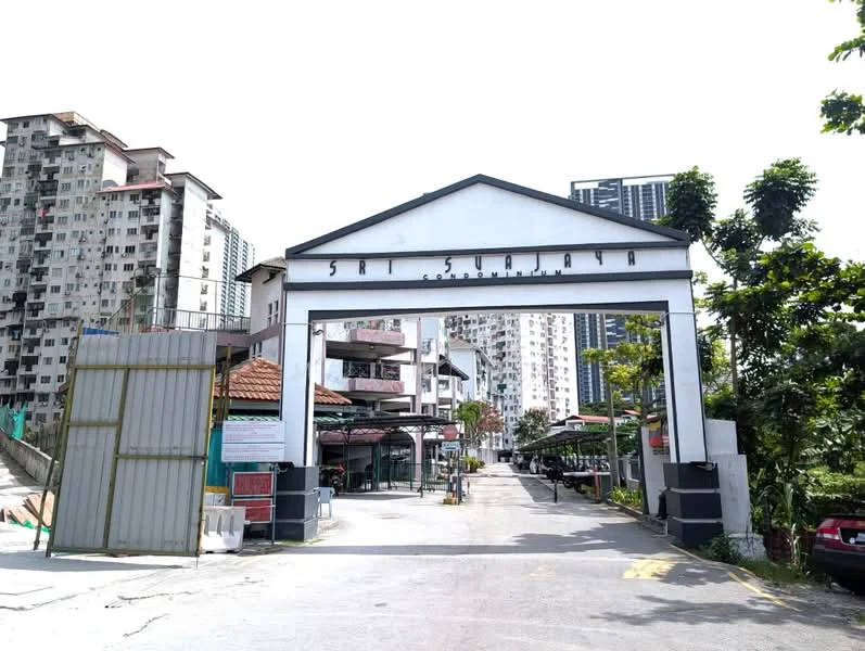 Exterior type: linked terrace house; features: white painted facade, gated entrance, paved driveway, surrounded by mature greenery, multi-storey buildings in background, open-air parking lot; style: modern.