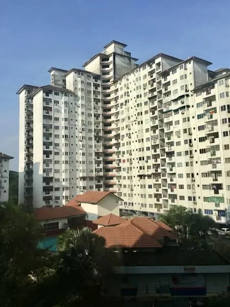 Exterior type: high-rise condominium; features: white painted facade, multiple balconies, flat roof, approximately 15-storey high-rise, surrounded by greenery, swimming pool visible in foreground, red tiled roofs of lower buildings, urban context with nearby structures; style: modern.