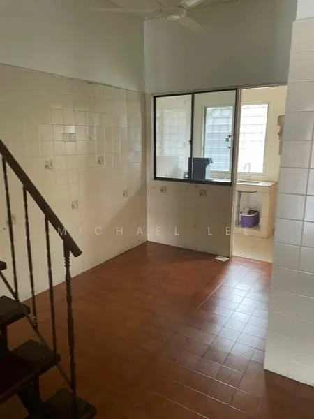 Room features: white tiled walls, brown tiled flooring, ceiling fan, large window, staircase, kitchen area visible, sink area visible, natural light from window.