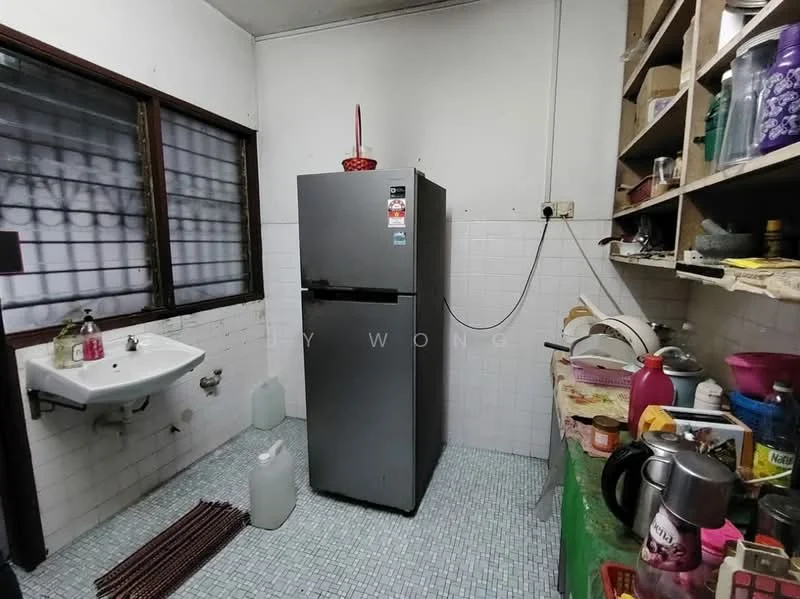 Kitchen features: grey refrigerator, single-bowl stainless-steel sink, white tiled walls, white tiled backsplash, blue mosaic tile flooring, wooden shelving, various kitchen utensils, plastic containers, dish rack, kettle, cutlery, cleaning supplies.