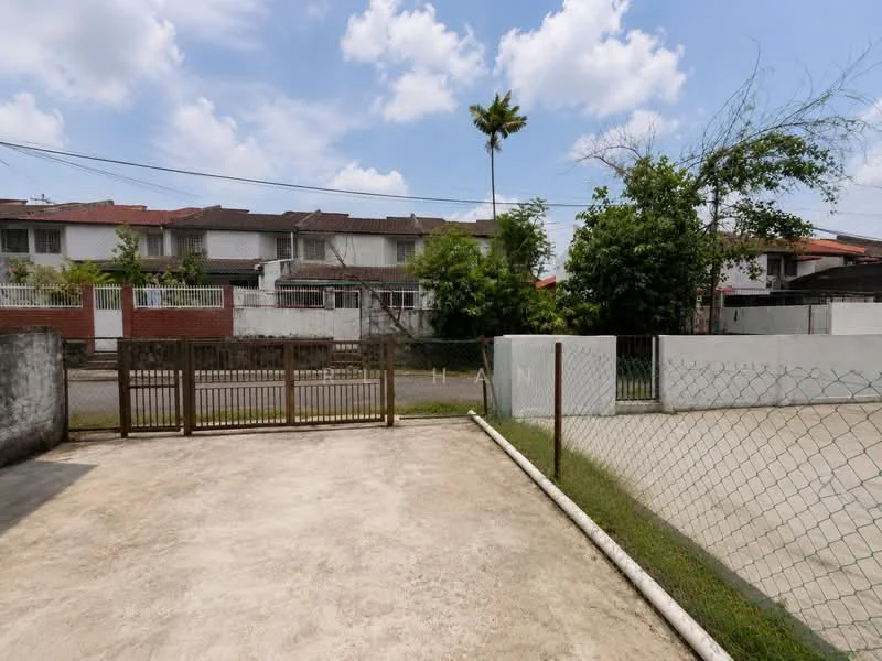 Exterior type: linked terrace house; features: concrete driveway, fenced yard, paved surface, mature palm tree, surrounding greenery, two-storey linked terrace houses in background, clear blue sky; style: modern.