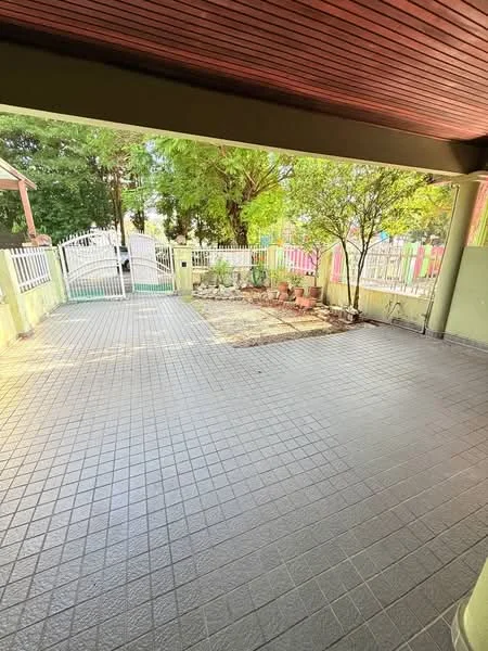Exterior type: linked terrace house; features: paved driveway, fenced perimeter, manicured garden area, mature trees, outdoor space with potential for landscaping, covered porch area, access gate, surrounding greenery; style: modern.