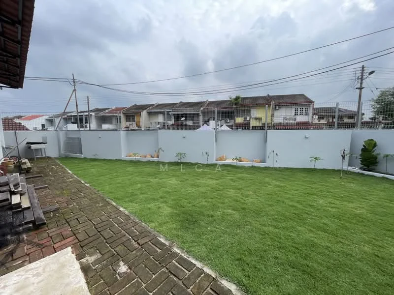 Exterior type: landscape garden; features: manicured lawn, brick paving, fenced perimeter, residential buildings in background, concrete wall, outdoor grill area; style: modern.