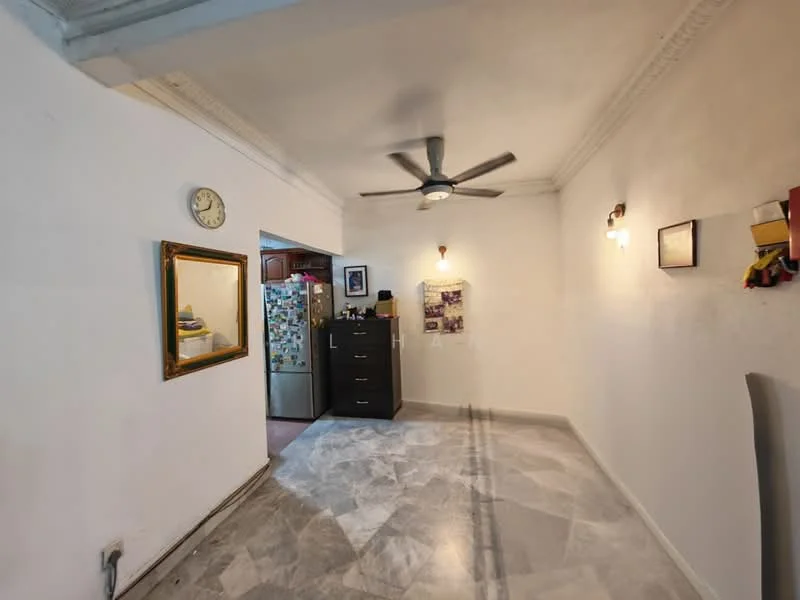 Living features: white painted walls, marble flooring, 5-blade ceiling fan with light, wall-mounted clock, framed mirror, two wall sconces, black chest of drawers, refrigerator, decorative wall art.