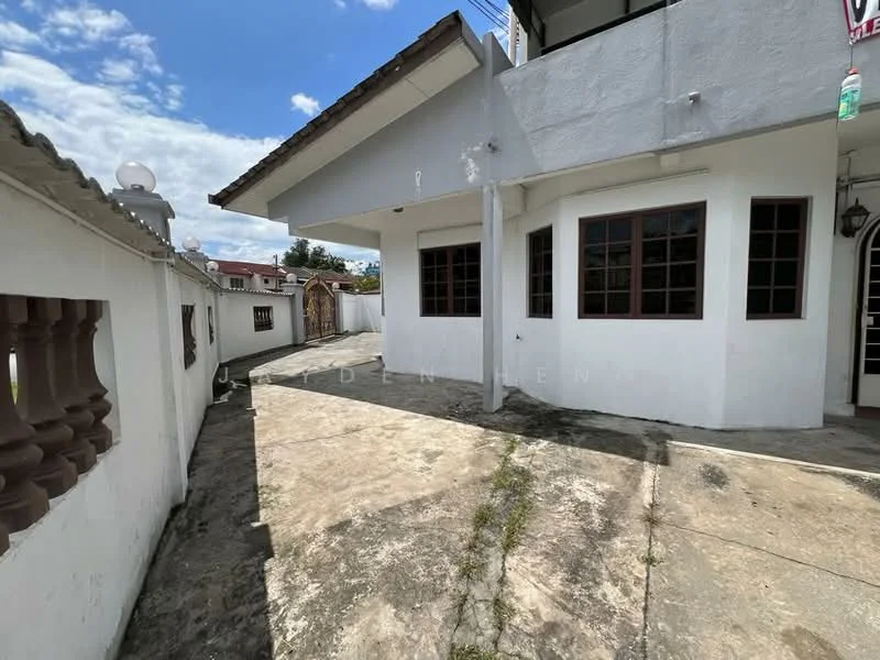 Exterior type: detached bungalow; features: white painted facade, flat roof, concrete flooring, windows with brown frames, manicured lawn area, side walkway, outdoor lighting fixtures, surrounded by low walls; style: modern.