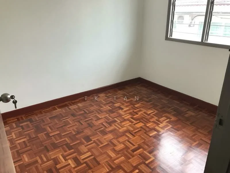 Room features: parquet wood flooring, white painted walls, single window, brown wooden door, neutral color scheme.