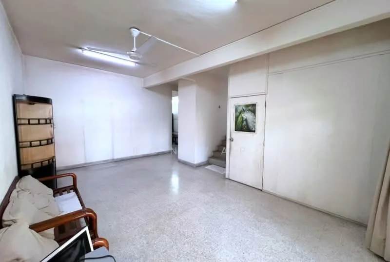Living features: white painted walls, polished concrete flooring, 5-blade ceiling fan, wooden sofa, staircase leading to upper level, door leading to another room, framed artwork on wall, natural light from window.