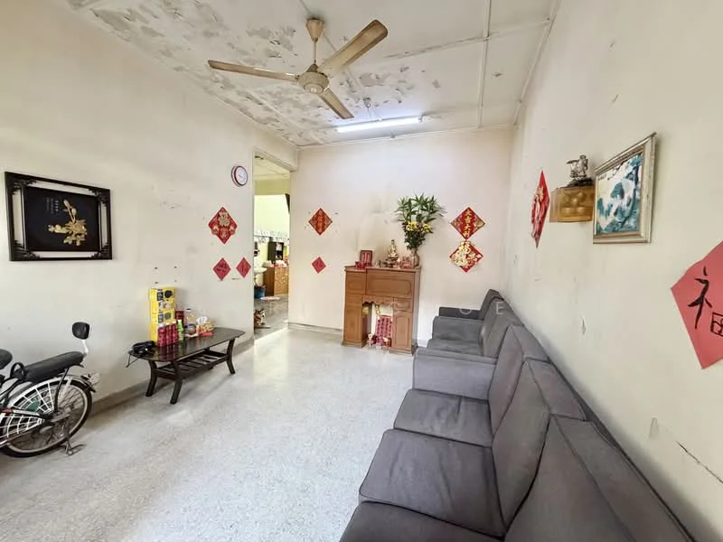 Living features: grey fabric sofa, wooden coffee table, ceiling fan, decorative wall art, wall-mounted clock, red decorative wall hangings, light-colored walls with peeling paint, tile flooring; style: traditional.