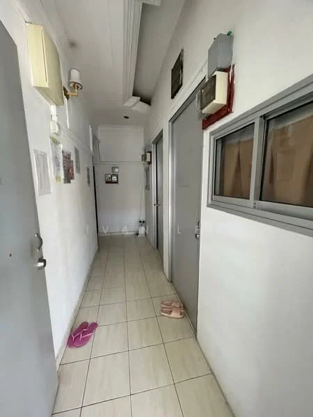 Hallway features: white painted walls, tile flooring, ceiling with crown moulding, wall-mounted light fixture, multiple doors, windows with metal frames, decorative wall art, slippers on the floor.