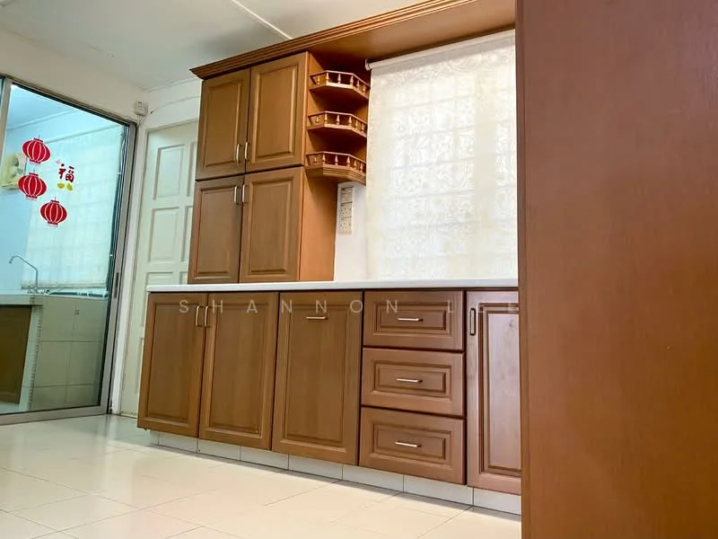 Kitchen features: brown wooden cabinetry, white countertop, built-in shelves, drawer storage, ceramic tile flooring, window with sheer curtains, wall-mounted cabinet, decorative wall hangings; style: modern.
