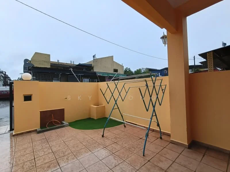 Exterior features: tiled flooring, yellow painted walls, clothes drying rack, green grass patch, outdoor light fixture, drainage outlet, surrounding buildings visible; style: modern.