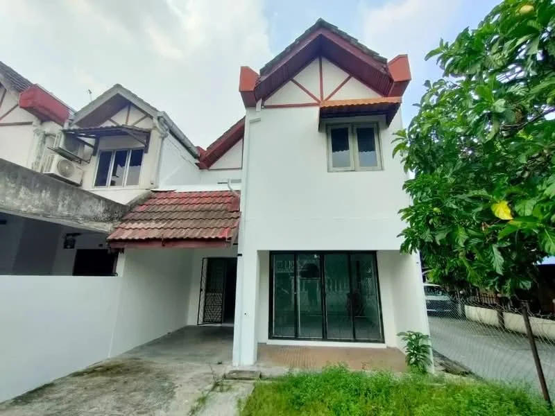 Exterior type: semi-detached house; features: white painted facade, red tiled roof, gabled roof design, two-storey structure, large glass windows, concrete driveway, manicured landscaping, air conditioning unit visible, front porch area, surrounded by greenery; style: modern.
