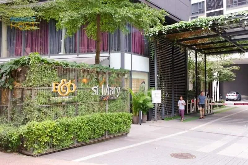 Exterior type: high-rise condominium; features: greenery with climbing plants, glass facade, covered entrance with metal framework, paved walkway, signage for 'EGO' and 'St Mary', visible car park area, urban landscaping, mature trees; style: modern.