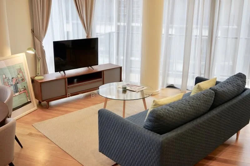 Living features: 3-seater fabric sofa in blue, coffee table with glass top, TV console with storage, wall-mounted TV, area rug, floor-to-ceiling windows with sheer curtains, wooden flooring, decorative artwork, table with magazines; style: modern; view: city.